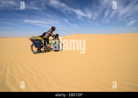 Mann schob Fahrrad über die Sanddünen der Sahara Wüste, Ägypten Stockfoto