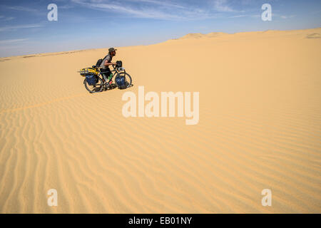 Mann schob Fahrrad über die Sanddünen der Sahara Wüste, Ägypten Stockfoto