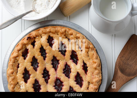 Hohen Winkel Schuss eine frisch gebackene Obstkuchen mit einem Gitter-Kruste. die Torte ist umgeben von Backen Elemente. Querformat. Stockfoto