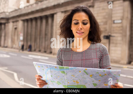 junge Frau Lesen einer Karte in der Stadt Stockfoto