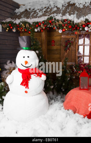 Großer Indoor Winter Schneemann mit Hut, umgeben von schönen Weihnachten Dekore, stehend auf dem Boden mit Baumwolle Schnee. Stockfoto