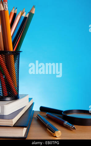 Booksa und Kugelschreiber mit Bleistift in Halter Korb auf blauem Hintergrund Stockfoto