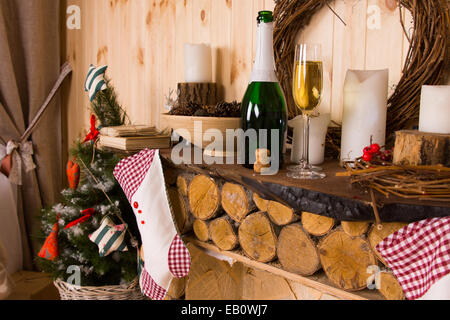 Stillleben mit rustikalen Log Mantel mit Wein, Strümpfen und Weihnachtsschmuck Stockfoto