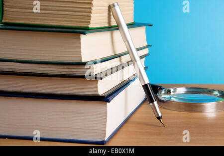 Stapel von Büchern und Kugelschreiber auf Holz Tisch Stockfoto