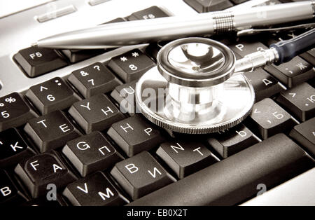 Stethoskop und Silber Stift auf Computer-Tastatur Stockfoto