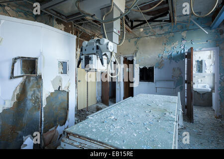 Ein Röntgengenerator und einer exponierten Blei-Wand in einem verlassenen Krankenhaus Radiologie Zimmer Tisch. Ontario, Kanada. Stockfoto