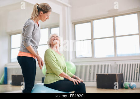 Porträt einer weiblichen Fitness Instruktor eine ältere Frau zu helfen. Porträt von weiblichen Trainer senior Frau Ausübung in Gesundheit zu unterstützen Stockfoto