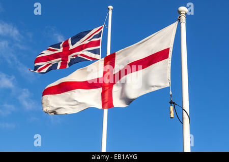 Flaggen von Union Jack und England, die vom Wind auf ihren jeweiligen Flagstacks, London, England, Vereinigtes Königreich, geblasen werden Stockfoto