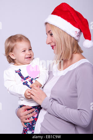 Glückliche Familie Mutter und Baby in Weihnachtsmütze Stockfoto