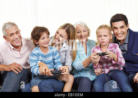 Glückliche Familie mit Controller spielen von Videospielen auf Smart TV im Wohnzimmer Stockfoto