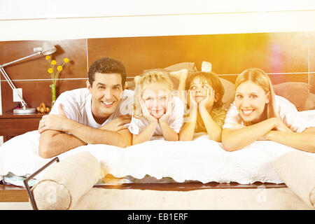 Glückliche Familie mit im Bett mit zwei Kindern im Sommer Stockfoto