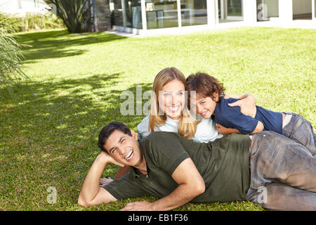 Glückliche Familie Verlegung mit Sohn im Garten im Sommer Stockfoto