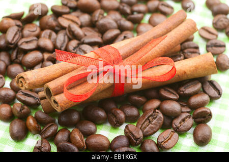 Zimt-sticks mit rotem Band auf Kaffeebohnen Stockfoto