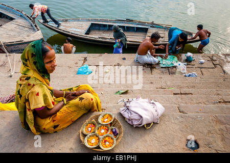 Blumenverkäuferin sitzen auf den Ghats, Varanasi, Uttar Pradesh, Indien Stockfoto