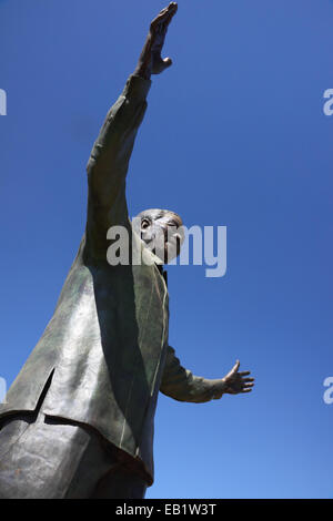Einen ungewohnten Blick auf eine Statue von Nelson Mandela mit seine Arme ausgestreckt und blauen Himmel hinter. Stockfoto