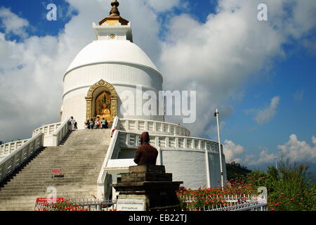 Gläubigen und Touristen besuchen den Shanti Stupa-World Peace Pagoda mit Min Bahadur Gurung.s Statue auf Ananda Hügel. Pokhara-Nepal. Stockfoto