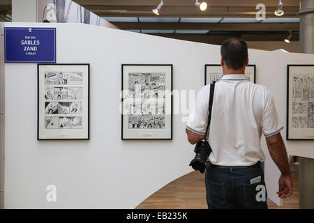 Mann liest Comics an Wand in der Brüsseler Comic-Strip-museum Stockfoto