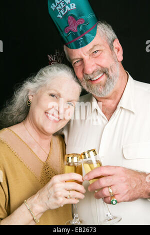 Schönes älteres paar Toasten in das neue Jahr mit Champagner.  Schwarzer Hintergrund. Stockfoto
