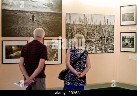 Touristen, die mit Blick auf Bilder der Wald entlaubt von Agent Orange im War Remnants Museum in Ho Chi Minh, Vietnam Stockfoto