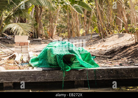 eine kleine thai Holzmotorboot unter Wartung mit einem Laken bedeckt Stockfoto