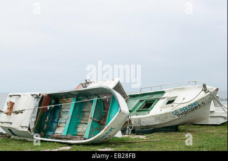 Zwei mexikanische Fischerboote mit Strand, eines davon auf der Seite im Gras, Campeche, Mexiko Stockfoto