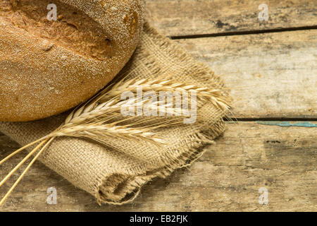 Laib Vollkornbrot mit Ohren auf Holz Hintergrund Stockfoto