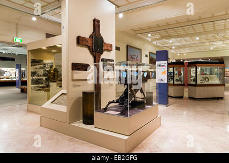 Ein Museumsgalerie anzeigen eine deutsche Maschinengewehr und Gedenkkreuz aus dem ersten Weltkrieg. Stockfoto