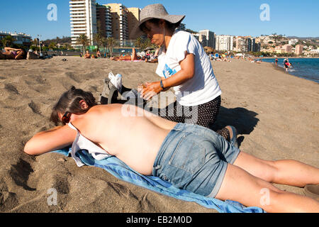 Frau, die eine Massage am Playa de Malagueta sandigen Strand, Malaga, Spanien Stockfoto