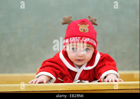 kleines Baby in rote Wintermütze Rentier, auf der Suche vor Stockfoto