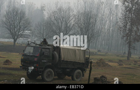 Srinagar, Kaschmir. 25. November 2014. Eine indische Armee steht Wache Seite Wahllokal die erste Phase der Abstimmung der Jammu und Kaschmir Zustand Versammlung Wahlen am Shadipora, Stadtrand von Srinagar, Indien kontrollierten Kaschmir. Tausende standen Schlange, um ihre Stimmen inmitten einem Boykott-Aufruf von muslimischen separatistischen Gruppen, die über die umstrittenen Himalaya-Region Indiens Souveränität ablehnen. Bildnachweis: Sofi Suhail/Alamy Live-Nachrichten Stockfoto