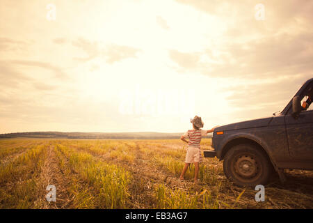 Mari junge stützte sich auf Auto im ländlichen Bereich Stockfoto