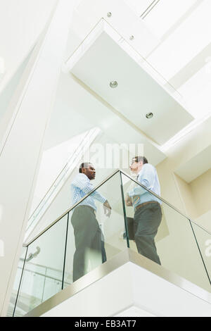 Niedrigen Winkel Blick auf Geschäftsleute sprechen auf Büro-Balkon Stockfoto