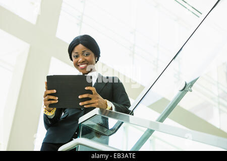 Schwarzen Geschäftsfrau mit digital-Tablette auf Büro-Treppe Stockfoto