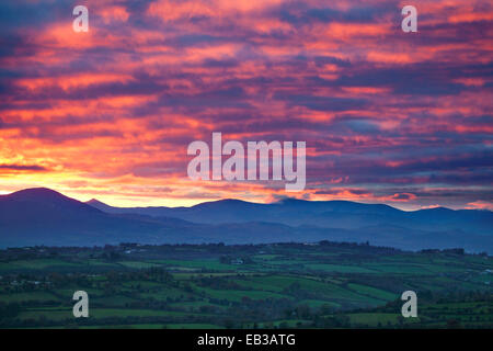 Sonnenuntergang über Ackerland von in der Nähe von Killarney, mit Blick auf die Macgillycuddy stinkt. Iveragh-Halbinsel, County Kerry, Irland. Stockfoto