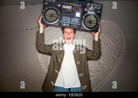 Kaukasischen Mann mit Boom-Box in der Nähe von Kreide Herz an Wand Stockfoto