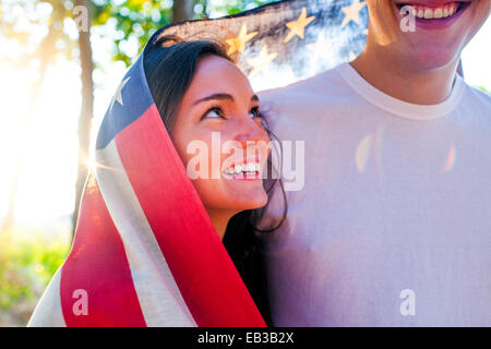 Kaukasische paar verpackt in amerikanische Flagge Stockfoto