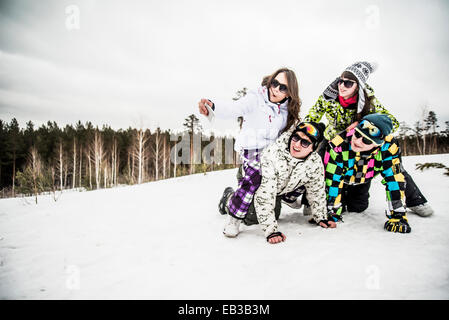 Kaukasische Freunde lächelnd im Schnee Stockfoto