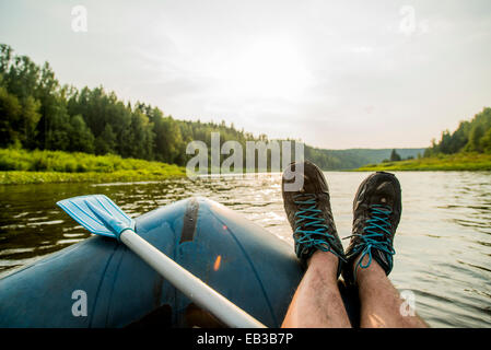 Man ruht Füße auf Boot im See Stockfoto