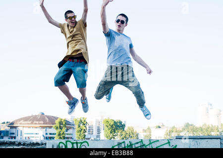Kaukasische Männer springen vor Freude in die Stadt Stockfoto