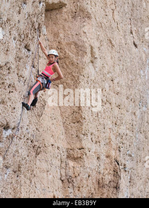 Gemischte Rassen Mädchen Klettern steile Klippe Stockfoto