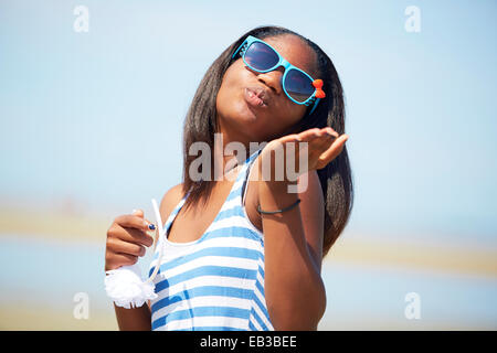 Schwarzer Teenager-Mädchen bläst Küsse im freien Stockfoto