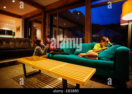 Mutter und Kinder gemeinsam im modernen Wohnzimmer entspannen Stockfoto