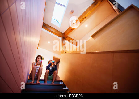 Gemischte Rassen Kinder mit Handys auf Treppe Stockfoto