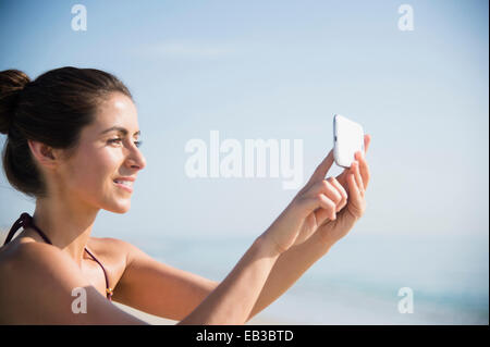 Kaukasische Frau Selfie mit Handy am Strand Stockfoto