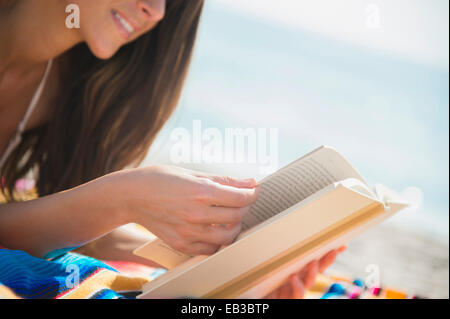 Kaukasische Frau Buch am Strand lesen Stockfoto