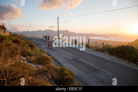 Frankreich, Korsika, Rennrad über Meer bei Sonnenuntergang Stockfoto