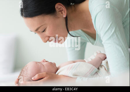 Asiatische Mutter halten Baby auf Bett Stockfoto