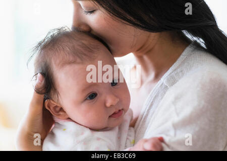 Asiatische Mutter halten und küssen baby Stockfoto