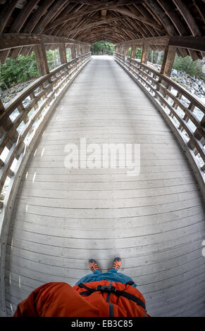 Mann, der auf einer Holzbrücke steht und ein Foto macht, Whistler, British Columbia, Kanada Stockfoto