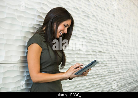 Hispanische Geschäftsfrau mit digital-Tablette in der Nähe von Wand Stockfoto
